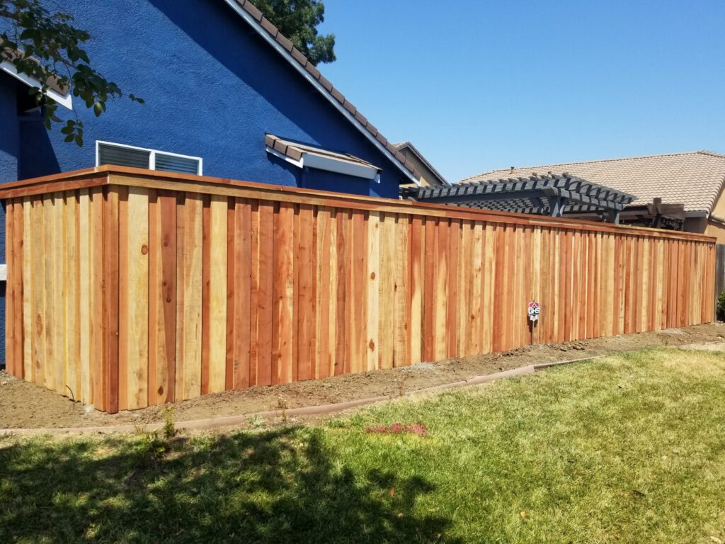 wooden garden fence against a blue house